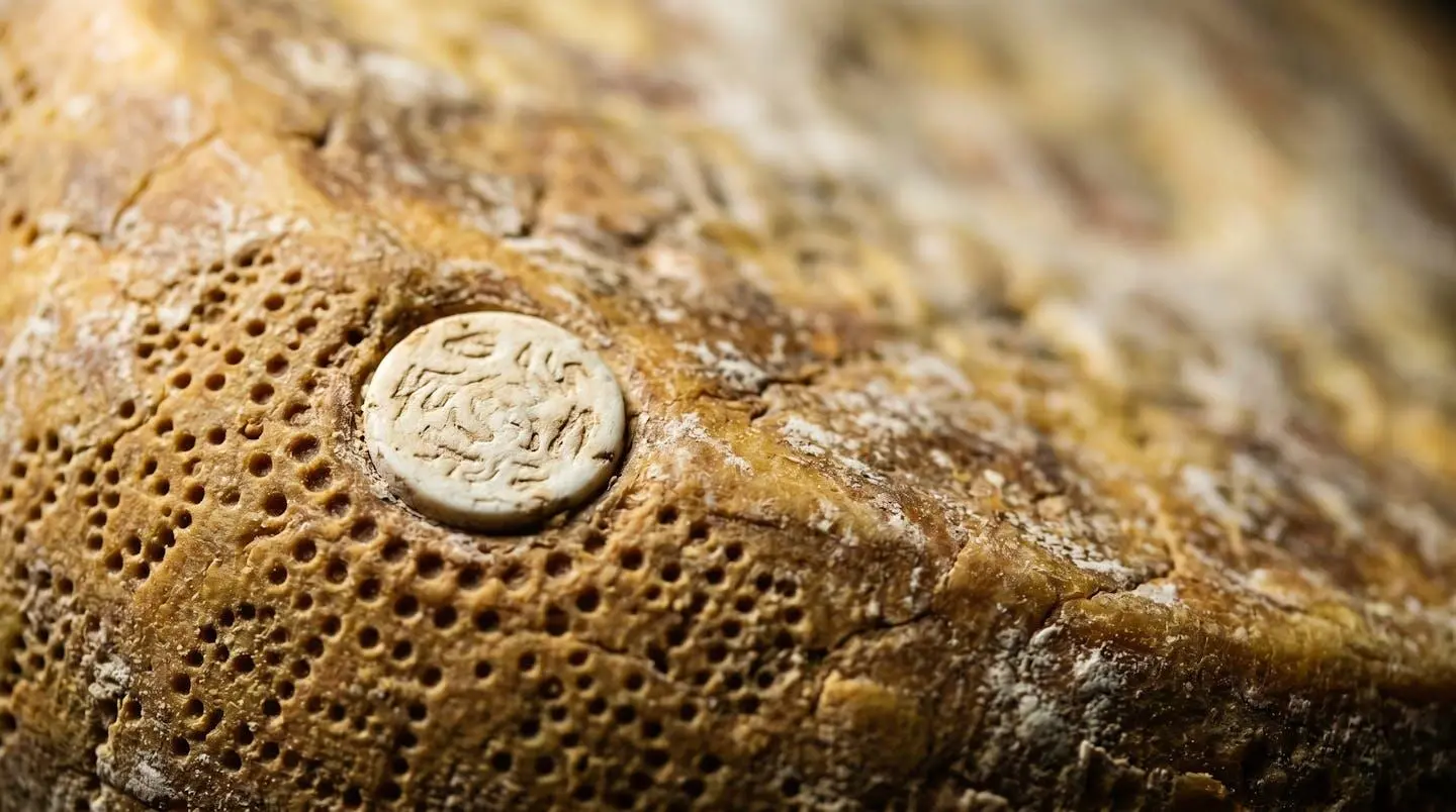 Close-up detail of authentication markings on artisanal cheese wheel surface