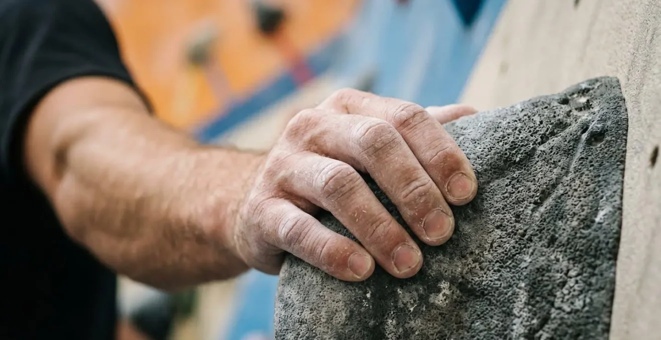Close-up of climber's hands on colorful holds representing the cognitive mapping process during route planning